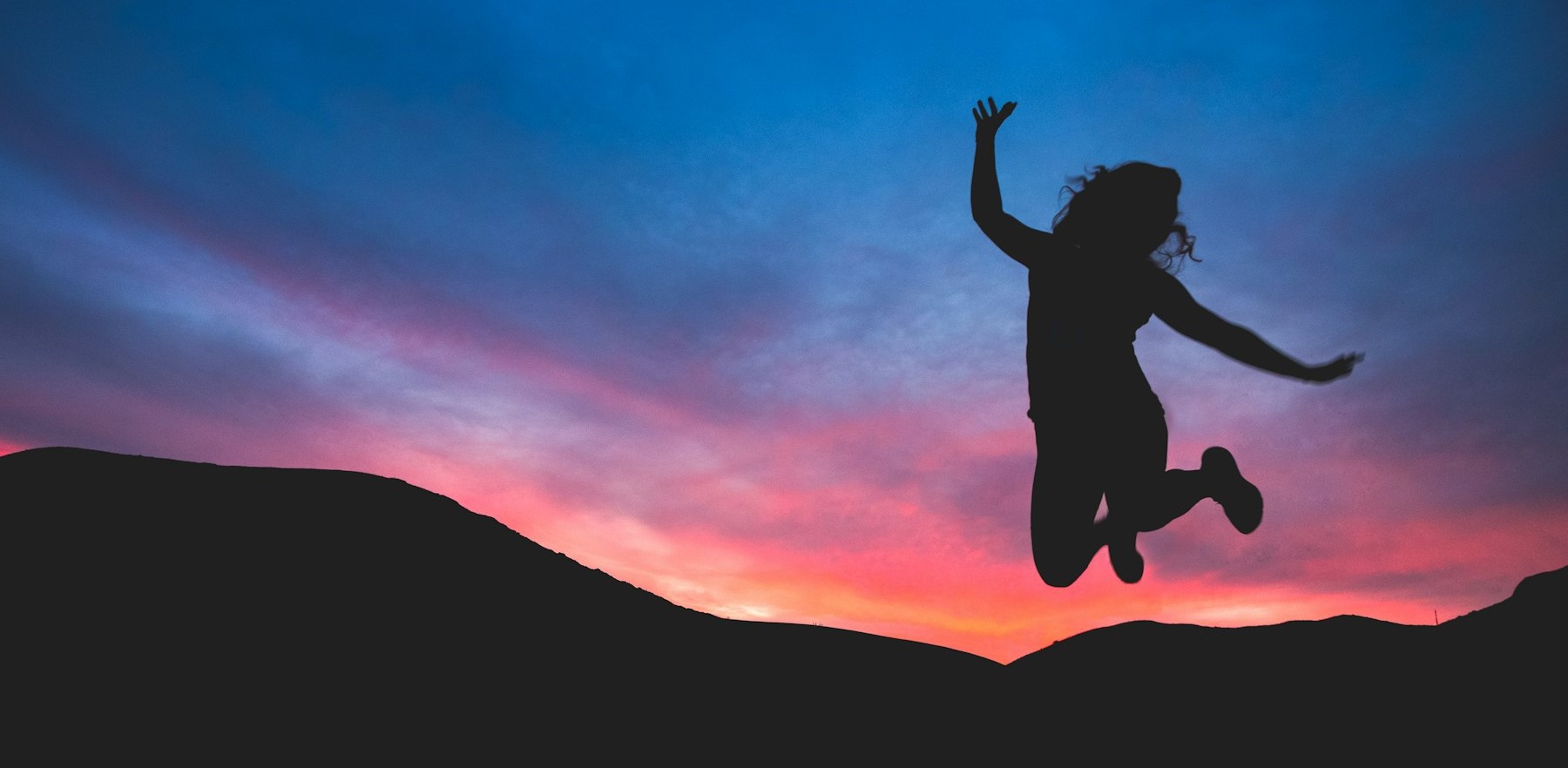 Stock photo of person leaping with joy, mid air, very enthusiastic