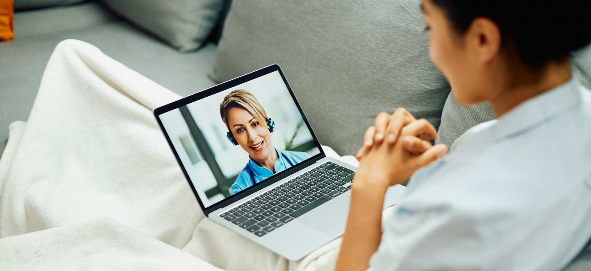 Stock photo of person in telehealth appointment from the comfort of their home